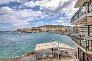 a view of the ocean from the balcony of a building at Staytopus Offshore Marsalforn Budget Room for Divers & Travelers in Marsalforn