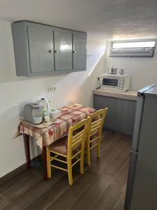 a small kitchen with a table with chairs and a microwave at Olive Mill Complex in Livadi