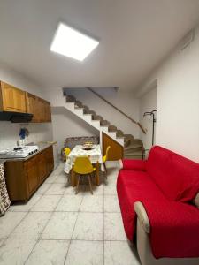 a living room with a red couch and a table at Il Vicoletto in Biccari