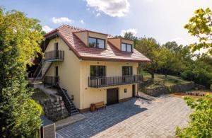 a yellow house with a staircase and a patio at Penzion Granier in Břeclav