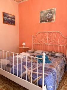 a bedroom with a bed with orange walls at Stella Marina in Giardini Naxos