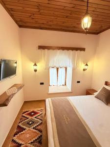 a bedroom with a large bed and a window at Vila Kalaja Kruje, Inside The Castle in Krujë +26 photos