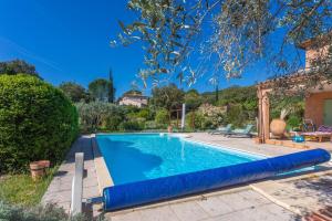 ein großes Schwimmbecken mit einer blauen aufblasbaren Poolblende in der Unterkunft Bastidon Cotignac in Cotignac