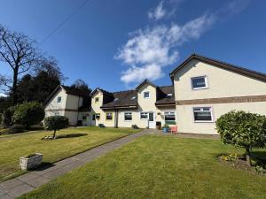 a large white house with a grass yard at Cunninghame 3 in Beith