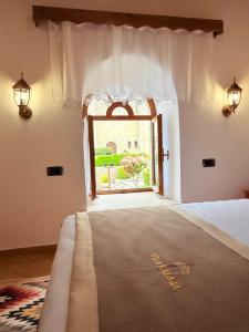 a bedroom with a bed and an open window at Vila Kalaja Kruje, Inside The Castle in Krujë