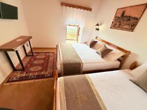 a hotel room with two beds and a television at Vila Kalaja Kruje, Inside The Castle in Krujë