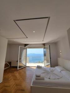 a bedroom with a large bed with a large window at Hotel Lusini in Vlorë