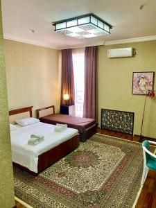 a hotel room with two beds and a window at Hotel Vardonze in Bukhara
