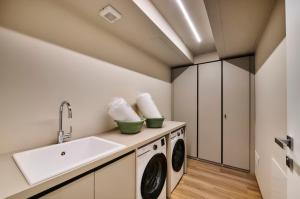 a laundry room with a sink and a washing machine at Monolocale 3 - viale Turati, Lecco in Milan