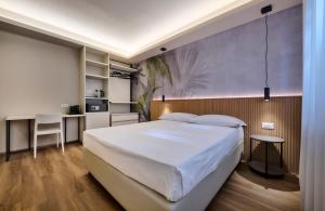 a bedroom with a large white bed and a desk at Monolocale 3 - viale Turati, Lecco in Milan