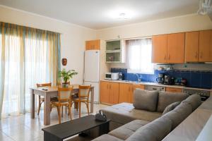 a living room with a couch and a table and a kitchen at Candia Relax House in Kandia