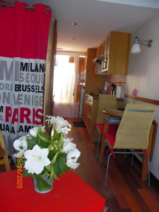a kitchen with a vase of white flowers on a table at Studio Face Mer in Quend-Plage
