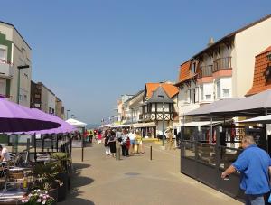 a group of people walking down a street with buildings at Studio Face Mer in Quend-Plage