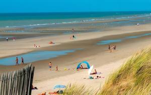 a group of people on a beach near the ocean at Studio Face Mer in Quend-Plage +2 photos