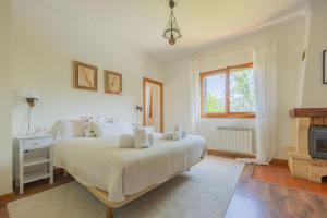 a white bedroom with a bed and a fireplace at Sea Garden in Mendiondo +61 photos