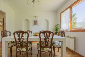 a dining room with a white table and chairs at Sea Garden in Mendiondo