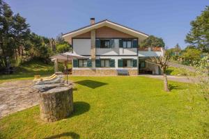 a large house with a grassy yard in front of it at Sea Garden in Mendiondo