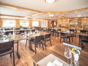a restaurant with wooden floors and tables and chairs at Hotel Alpenblick in Weissbad