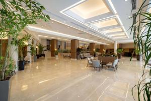 a lobby with tables and chairs and plants at Seven Seas Hotel Life - Ultra All Inclusive & Kids Concept in Kemer +195 photos
