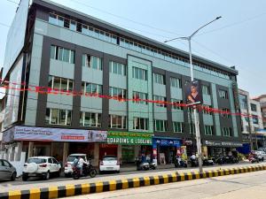a building on a street with cars parked in front of it at Hotel Sai in Udupi