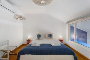 a white bedroom with a large bed with blue sheets at Casa Tejo Villa com Jaccuzi in Valada