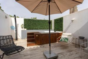 an umbrella on a patio with a tub and a chair at Casa Tejo Villa com Jaccuzi in Valada