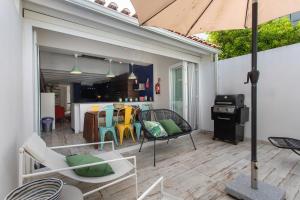 a patio with chairs and an umbrella and a kitchen at Casa Tejo Villa com Jaccuzi in Valada
