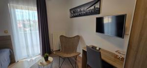 a room with a chair and a television on a wall at Villa Kristina in Rovinj