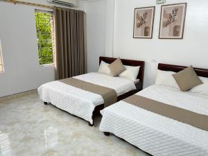 a bedroom with two beds and a window at An Phú Stay & Coffee in Cửa Lô