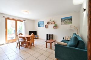 a living room with a blue couch and a table at Appartement Le Rucher in Alex