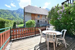 a patio with a table and chairs on a deck at Appartement Le Rucher in Alex