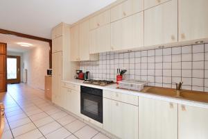 a kitchen with white cabinets and a stove top oven at Appartement Le Rucher in Alex +14 photos