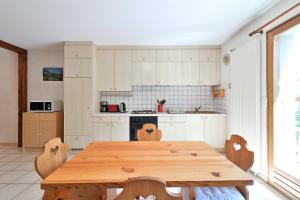 a kitchen with a wooden table and chairs in it at Appartement Le Rucher in Alex