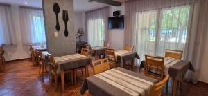 a restaurant with wooden tables and chairs and windows at Villa Kristina in Rovinj