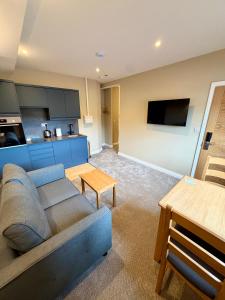 a living room with a couch and a kitchen at Grindal Studio Apartments - Newly Opened Luxury Accommodation in St Bees