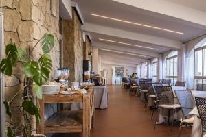 a restaurant with tables and chairs and a stone wall at Hotel Tirreno in Trapani