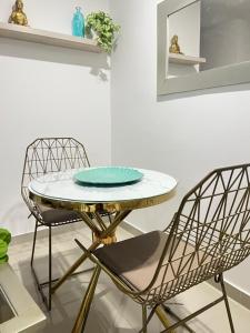 two chairs and a table with a plate on it at Apartamento COMPLETO Nuevo Norte de Valledupar-1 Habitación, Balcón y Parqueadero in Valledupar