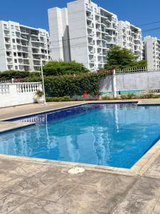 a blue swimming pool in front of some tall buildings at Apartamento COMPLETO Nuevo Norte de Valledupar-1 Habitación, Balcón y Parqueadero in Valledupar