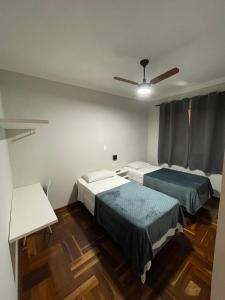 a bedroom with two beds and a ceiling fan at Hotel Silver in Rio das Pedras