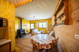 a dining room with a table in a room with yellow walls at Gîte Des Houx in Le Soulié