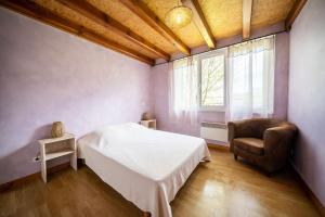 a bedroom with a bed and a chair and a window at Gite Fontaine in Le Soulié +14 photos