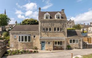 a large stone house with a blue door at The Painswick in Painswick