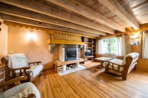 a living room with a fireplace and wooden floors at Gîte Des Myrtilles in Le Soulié