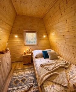 a bedroom with a bed in a wooden cabin at Bieszczadzki Reset A-Frame in Bukowiec
