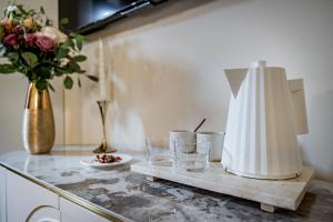a kitchen counter with glasses and a vase with flowers at Gold Artè Collection in Florence +32 photos