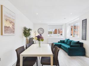 a living room with a table and a green couch at Luxury Two Bed | Sleeps 6 | 5 beds in Brent Station
