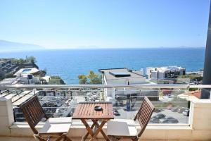 a balcony with a table and chairs and the ocean at Hotel Lusini in Vlorë