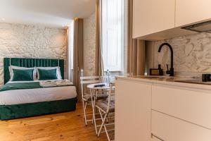 a small bedroom with a bed and a kitchen at Celtic Lodge - Guest House in Viseu