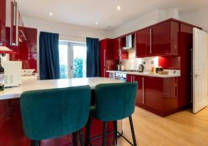 a kitchen with red cabinets and blue chairs at Spacious 3 bed, Parking, Long stays welcome, Relocators, Families, Contractors in Knaresborough