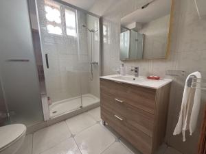 a bathroom with a shower and a sink and a toilet at Desconectaengalicia El Pescador, vistas al puerto, 200m playa in Portonovo +32 photos